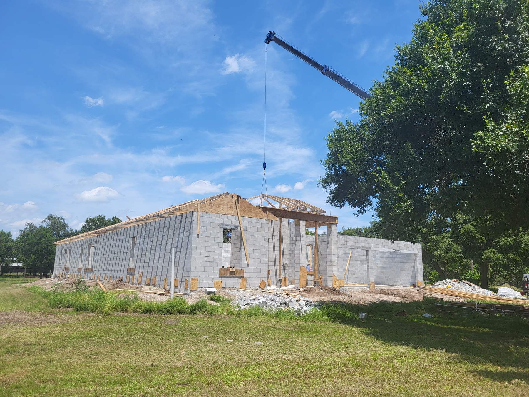 New home construction showing gable framing, garage structure, and roof underlayment