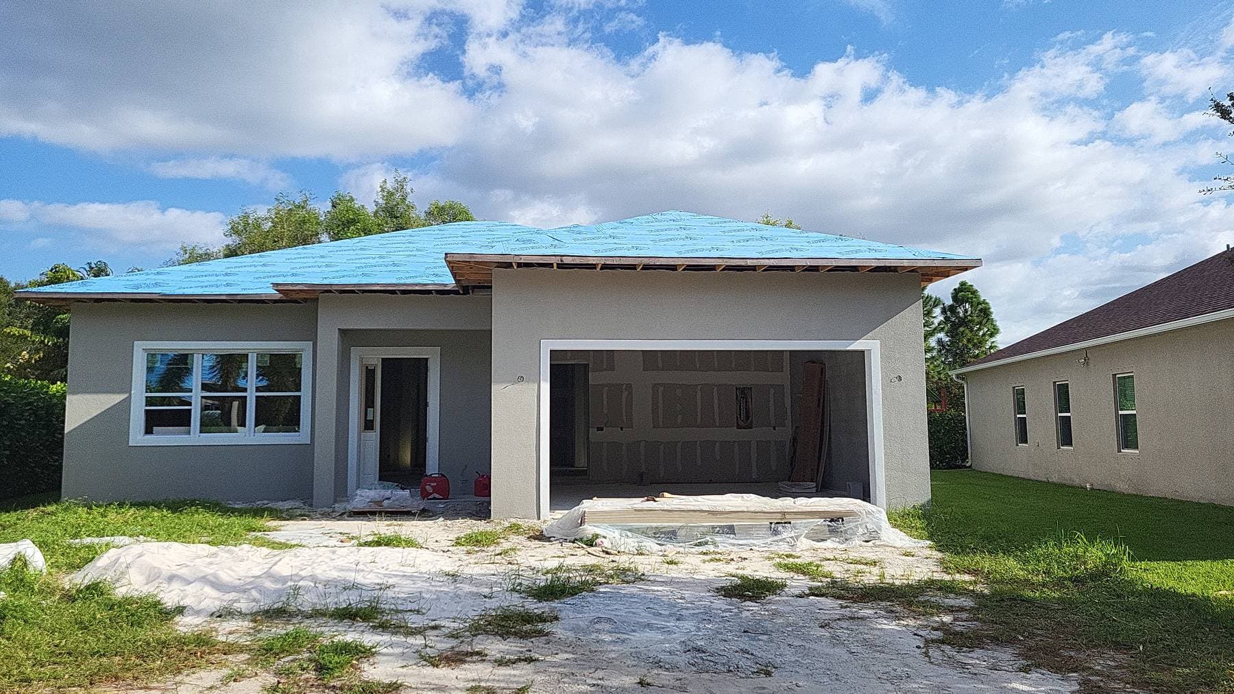Covenant Builders custom home exterior nearing completion with finished stucco and installed windows